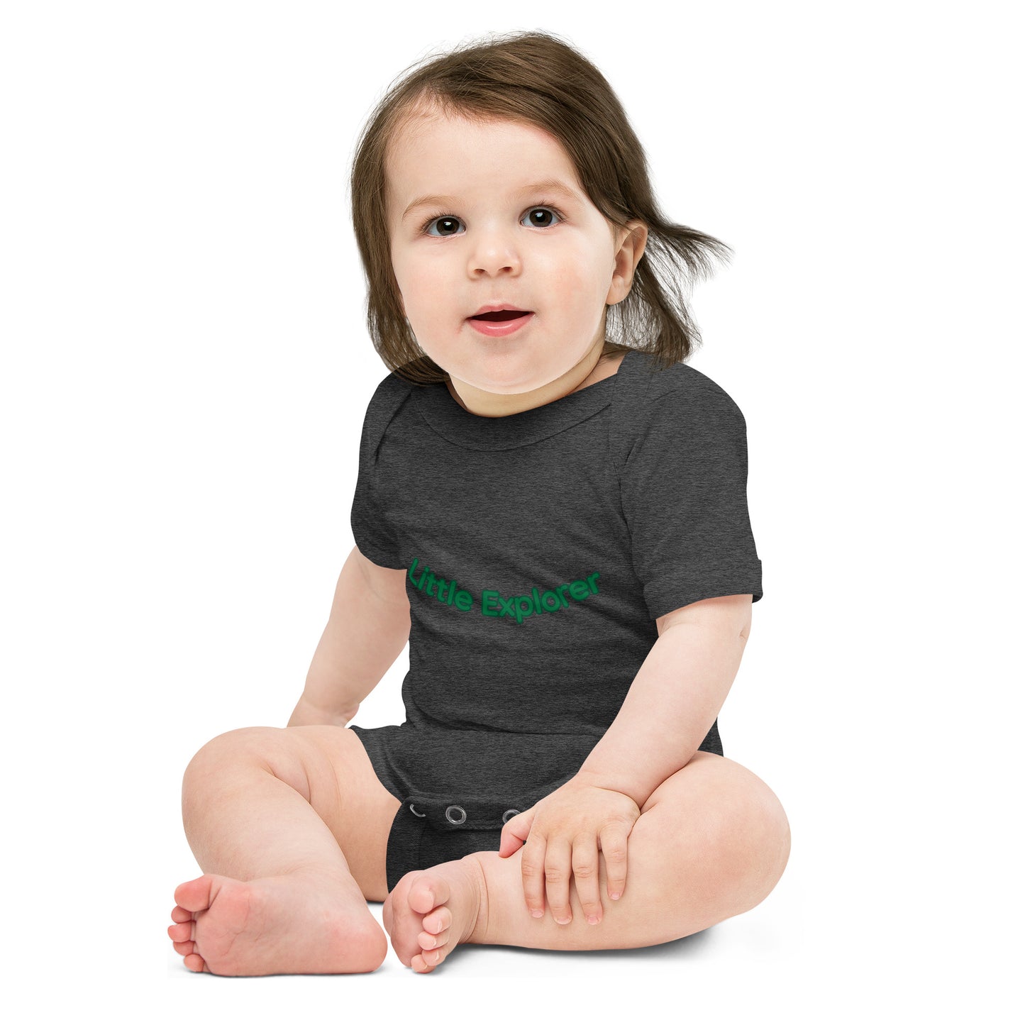 Child wearing a dark gray onesie with 'Little Explorer' text on a white background