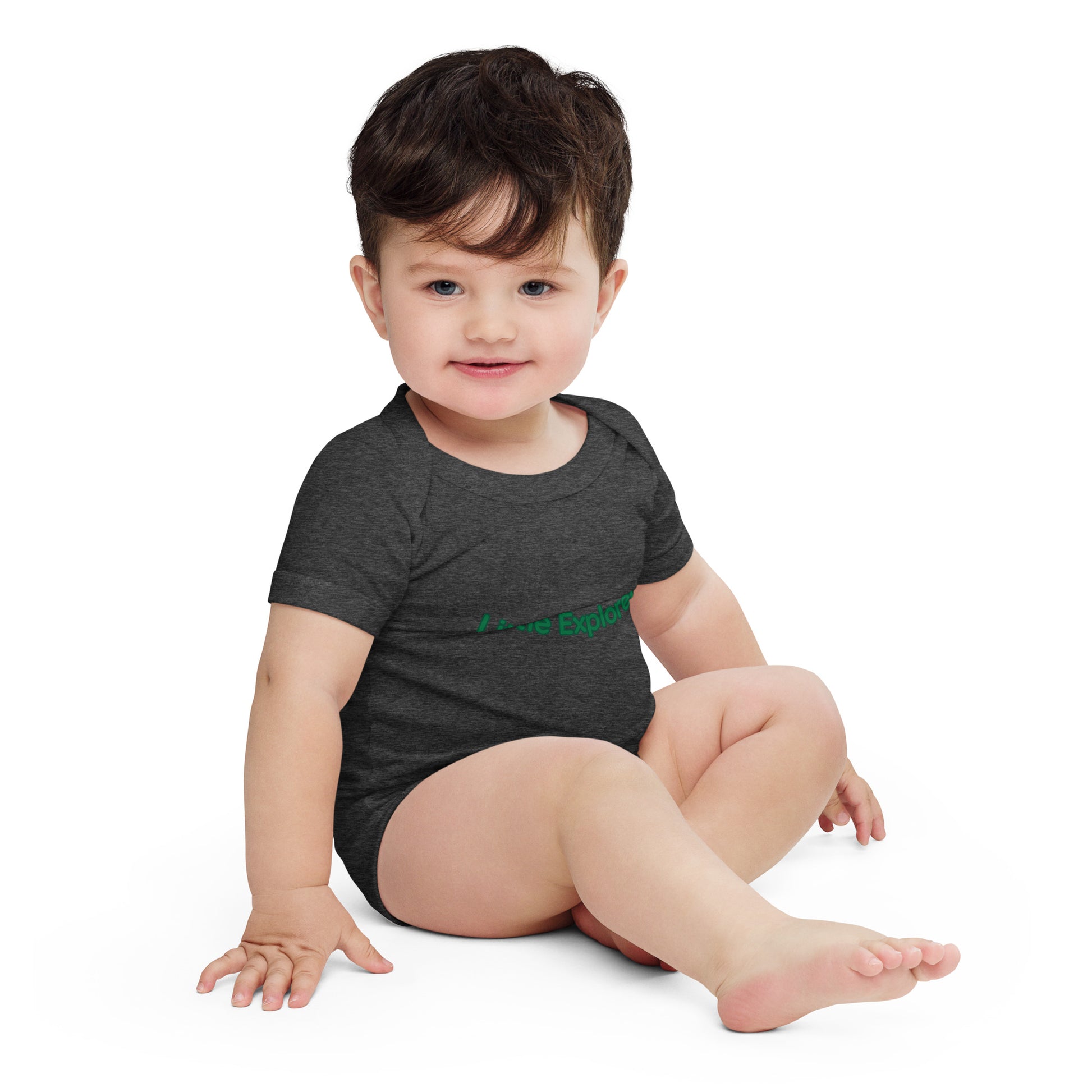 Baby wearing a dark gray onesie with green text on a white background